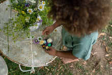 Load image into Gallery viewer, Child playing with dark baby nins and flowers
