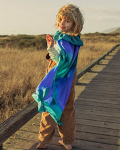 Load image into Gallery viewer, Kid on a wood board walk next to a grass field with a ocean silk cape on
