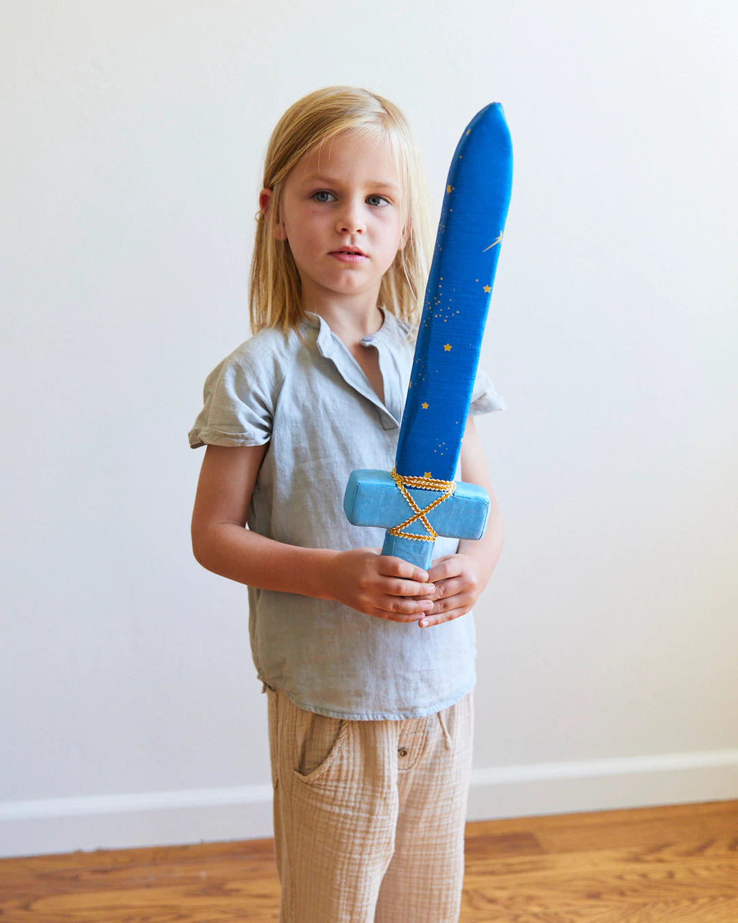 Kid holding a foam sword covered in a celestial star silk fabric