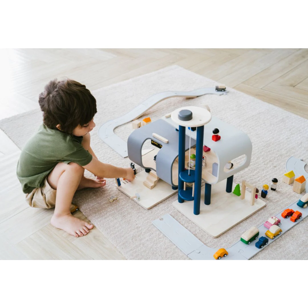 Child playing with plan toys central station