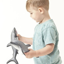 Load image into Gallery viewer, Toddler standing and holding two natural rubber dolphins
