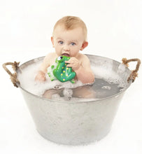 Load image into Gallery viewer, Baby taking a bath in a tin chewing on rubber frog

