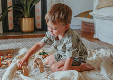 Load image into Gallery viewer, child playing on a blanket with wooden toys wearing Organic Short-Sleeve Tee in Herb Print
