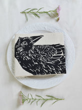 Load image into Gallery viewer, organic cotton crow tea towel folded on a plate
