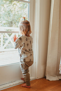 Child standing in front of a sun filled window wearing the Organic Short-Sleeve Tee in Herb Print