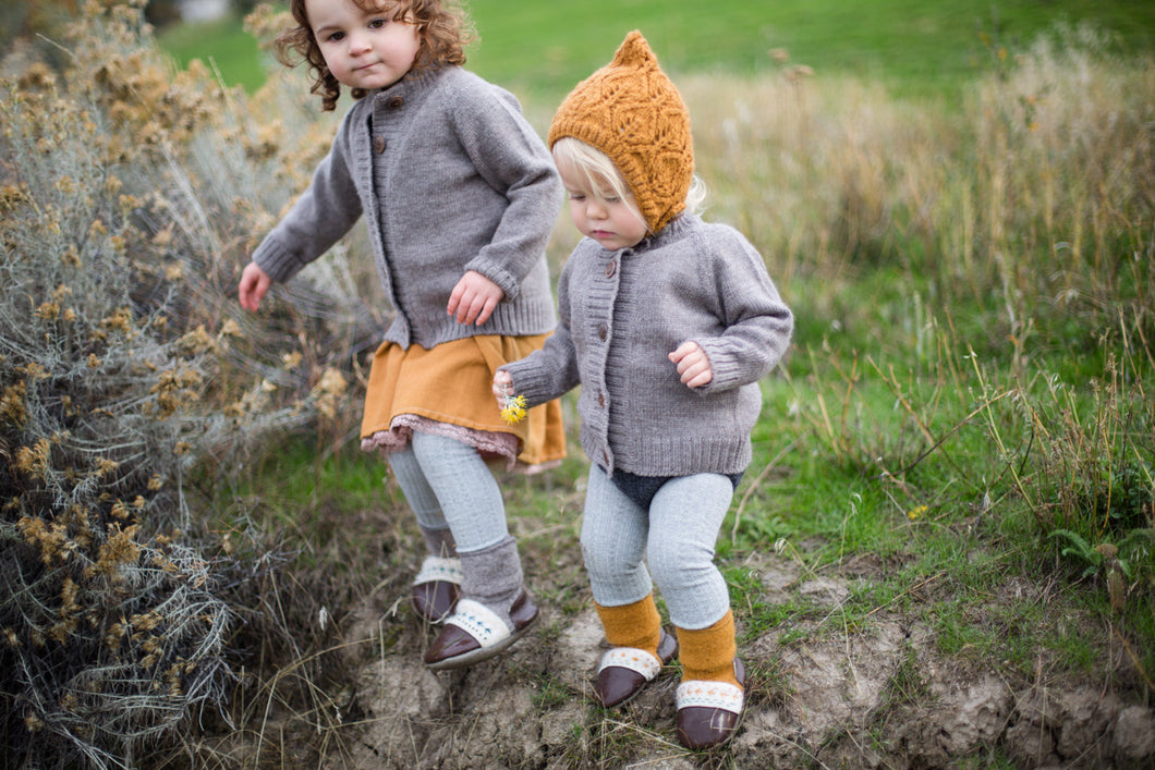 Kids playing outside wearing merino wool bonnets by Nook Design