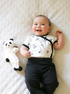 Flat Panda Bear Baby Teething Toy next to a smiling baby
