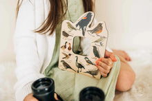 Load image into Gallery viewer, child sitting down holding a pair of binoculars and a double sided bird finder
