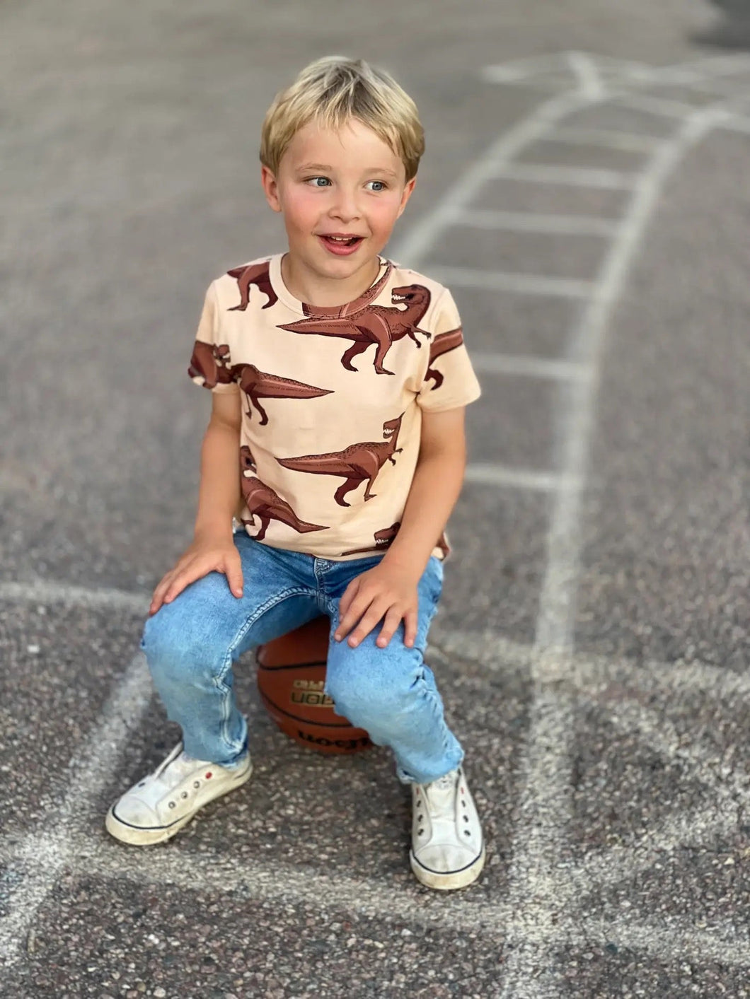 Child wearing Juno short sleeve dinosaur tee by The Striped Cat
