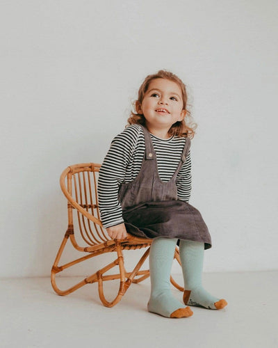 child sitting on a chair wearing knee high socks a jumper and a Organic Striped Raglan