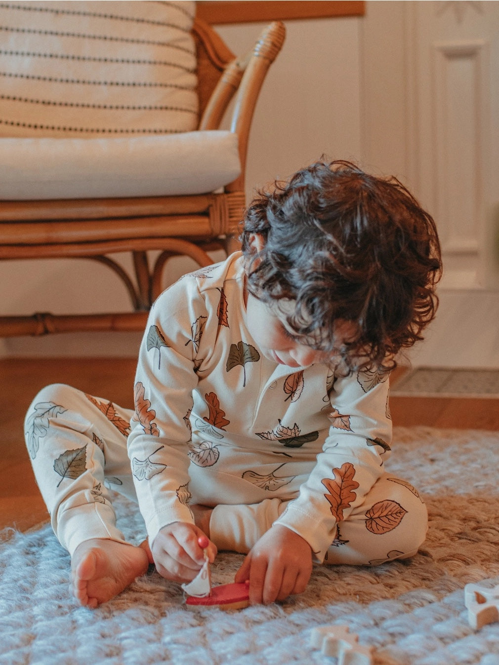 chid playing on the floor wearing a matching long autumn leaf set by ZiwiBaby